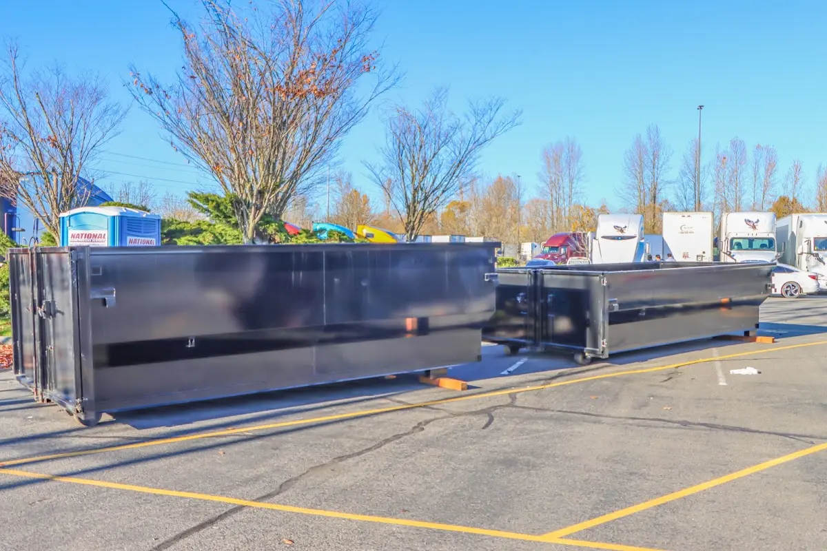 Professional dumpster rental service with roll-off container on residential driveway in Gonzalez